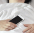 Woman sleeping in bed and holding a mobile phone. - Газета За изобилие